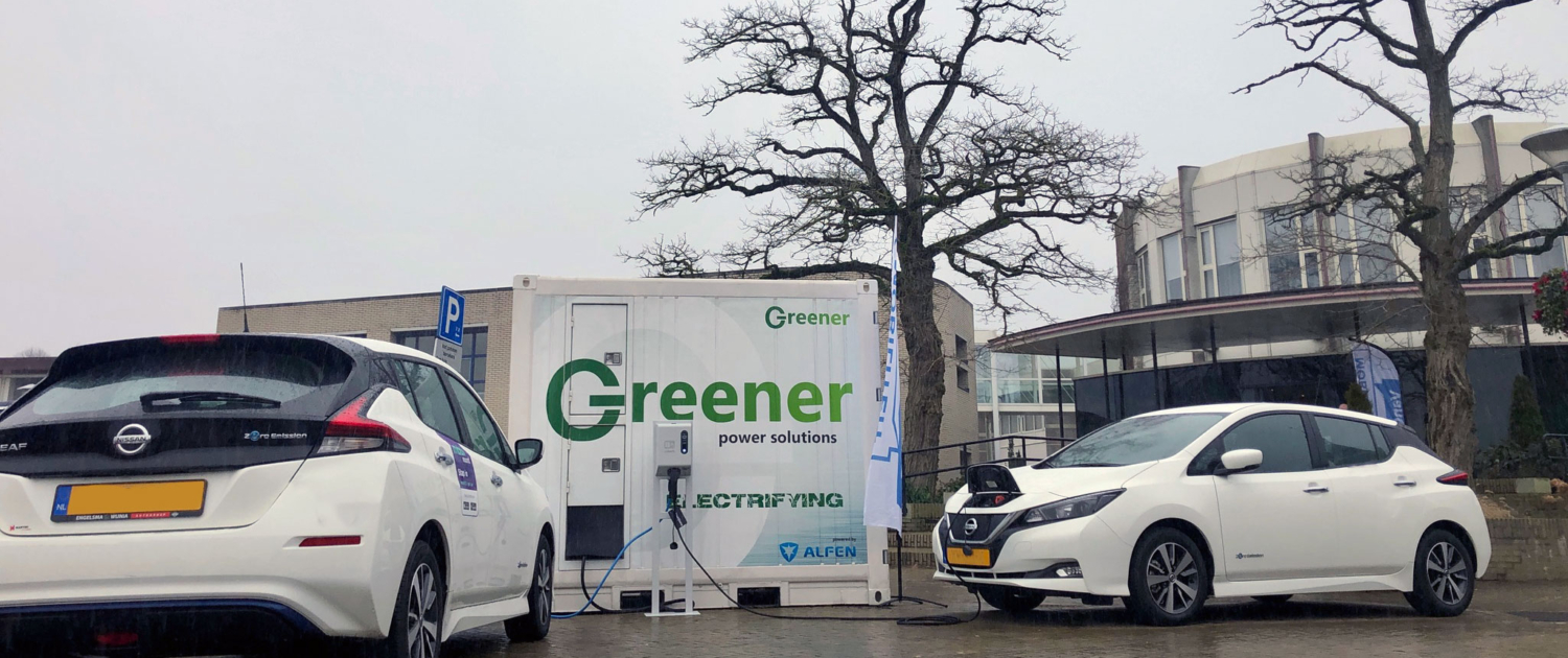 Twee elektrische auto's worden opgeladen door een laadpaal die gevoed door een Greener batterij